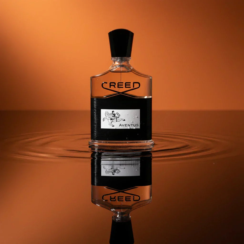 Creed Aventus bottle resting on an orange surface in shallow water