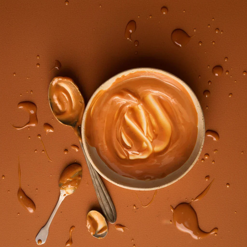 Caramel in a bowl on an orange surface — caramel fragrance note spotlight