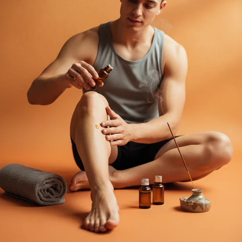 Athlete applying essential oil muscle recovery blend to legs after training — aromatherapy sports recovery