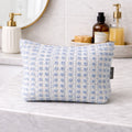 Blue floral-patterned pouch on a bathroom counter with toiletries in the background