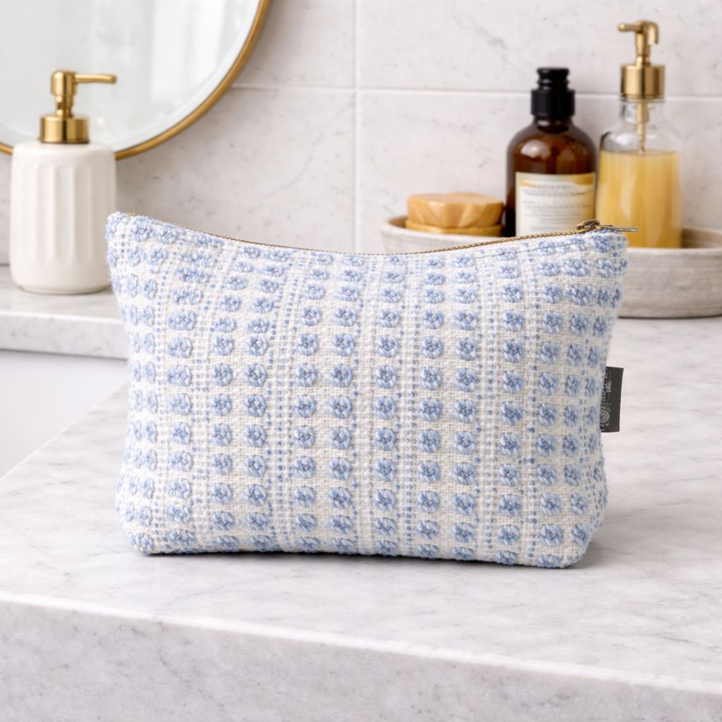 Blue floral-patterned pouch on a bathroom counter with toiletries in the background