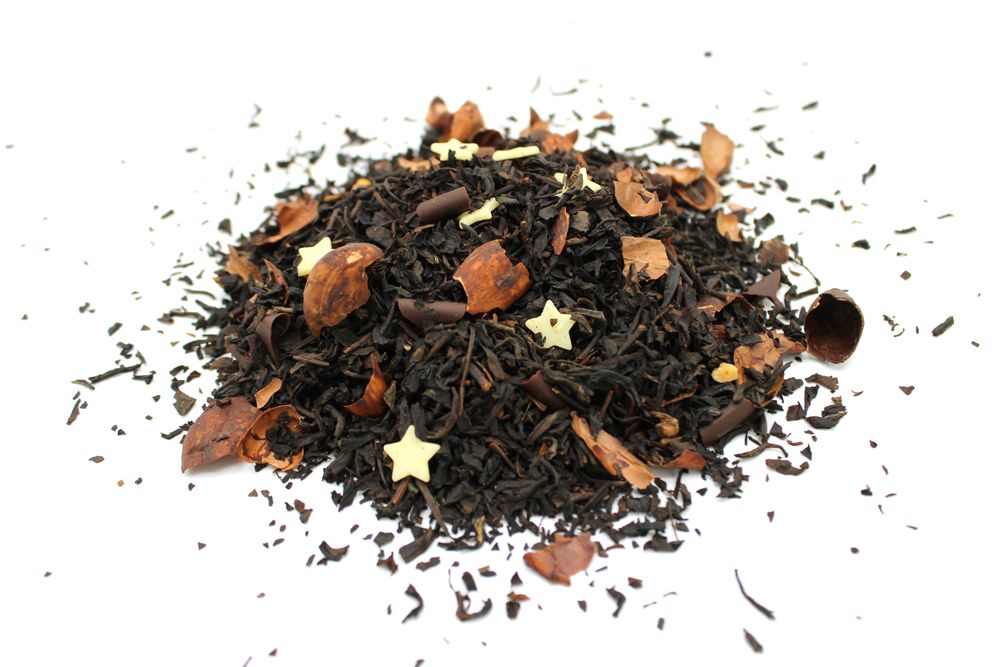Heap of black tea leaves with star anise on a white background