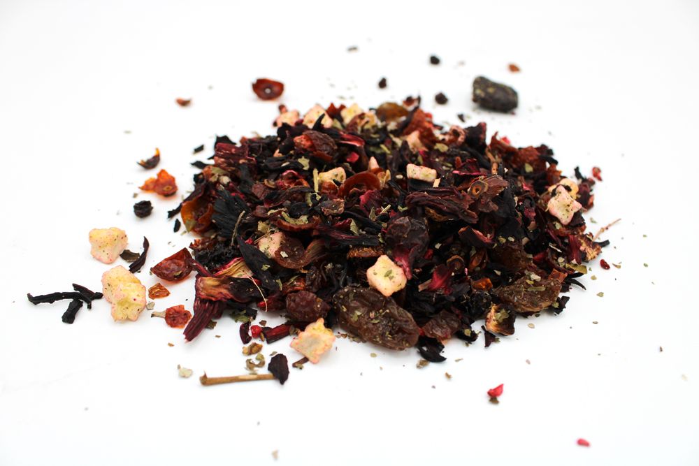 Spice mix including dried berries, herbs, and possibly fruits on a white background