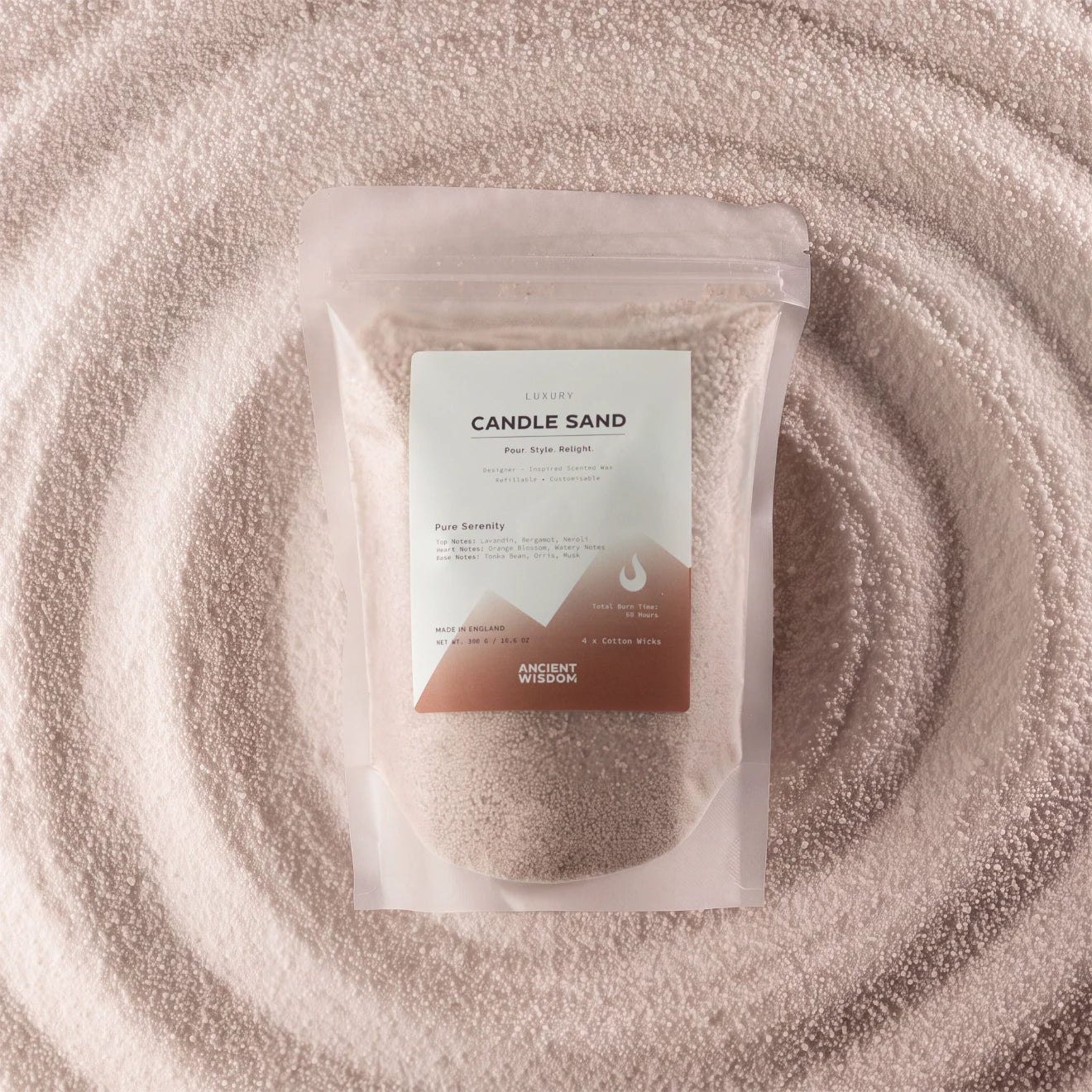 A clear stand-up pouch containing fine beige candle sand, centered on a matching beige powder background with concentric circular texture. The front label reads 'CANDLE SAND' and 'ANCIENT WISDOM'.