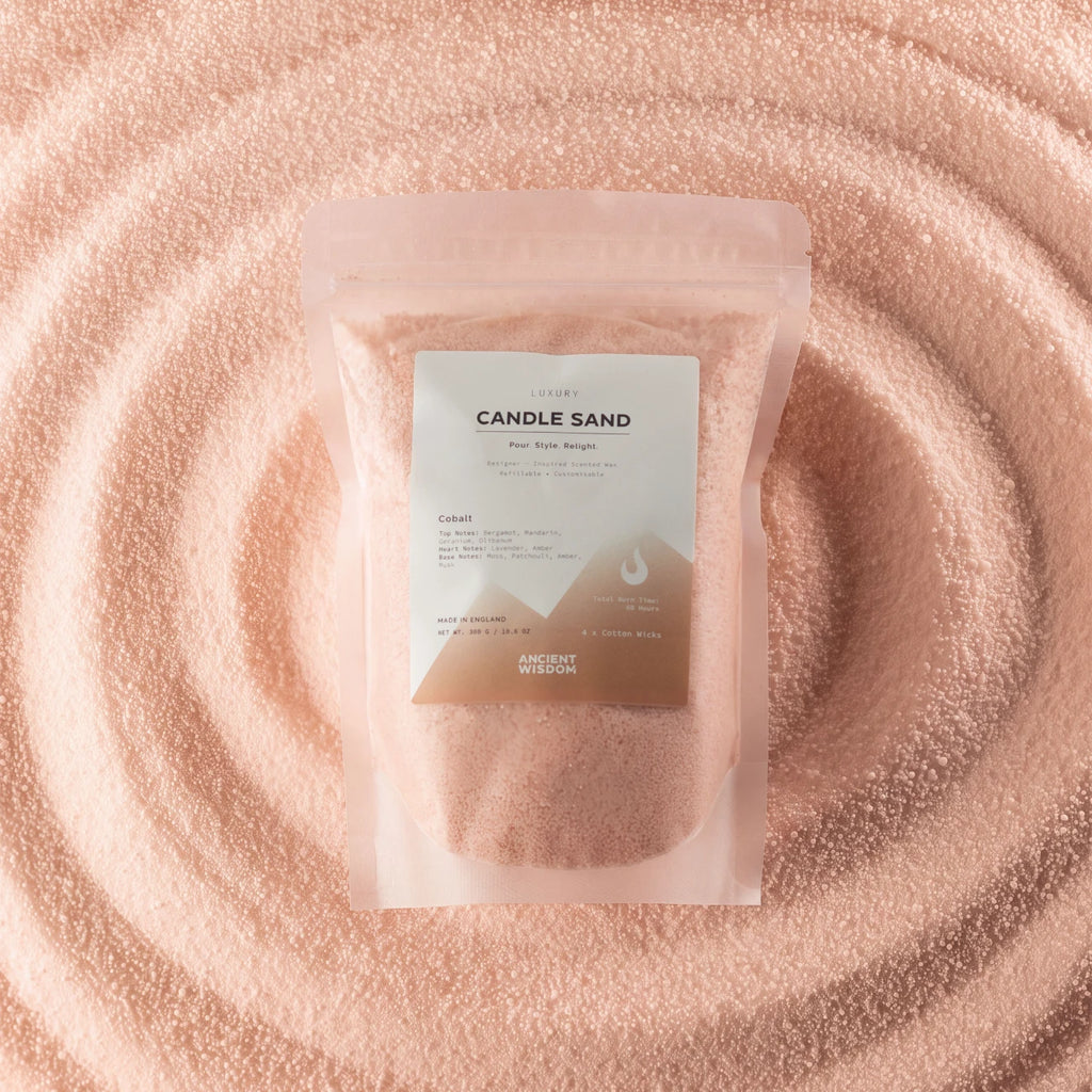 A clear stand-up pouch labeled 'CANDLE SAND' containing pale pink salt-like powder, placed on top of a matching pink textured surface with concentric circular ripples.