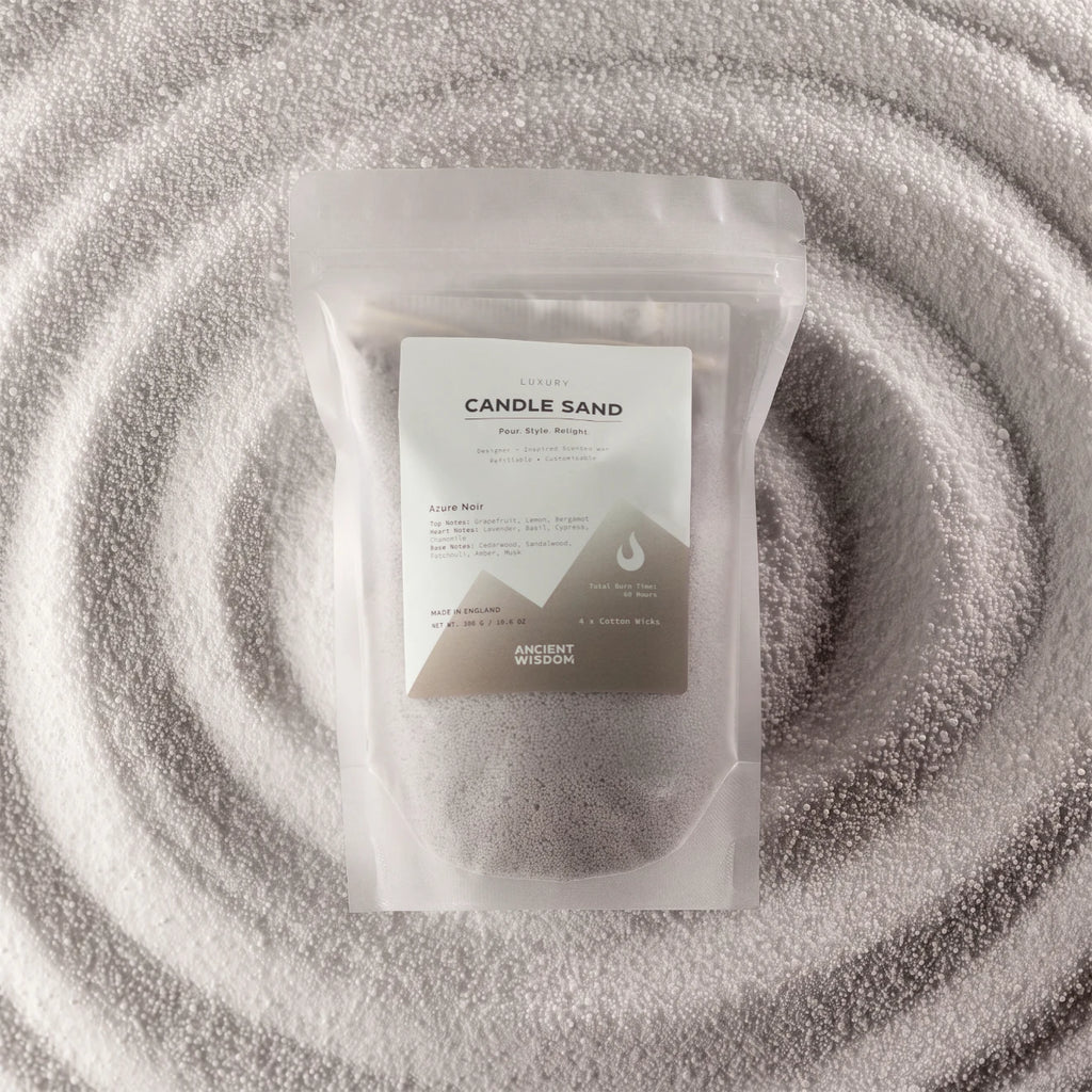 A clear resealable pouch containing white wax melts or wax beads, with a white label reading 'CANDLE SAND' and 'ANCIENT WISON', placed on a textured white fabric background with concentric circular ripples.