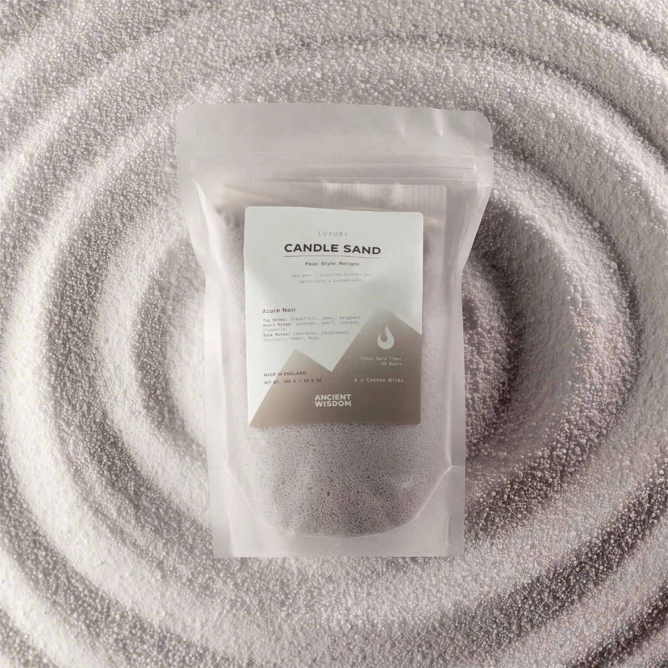 A clear resealable pouch containing white wax melts or wax beads, with a white label reading 'CANDLE SAND' and 'ANCIENT WISON', placed on a textured white fabric background with concentric circular ripples.