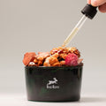 Hop Hare Diffusing Crystals & Floral Set - The Devil Black container with floral elements and a dropper adding liquid, featuring the 'lop flare' brand.