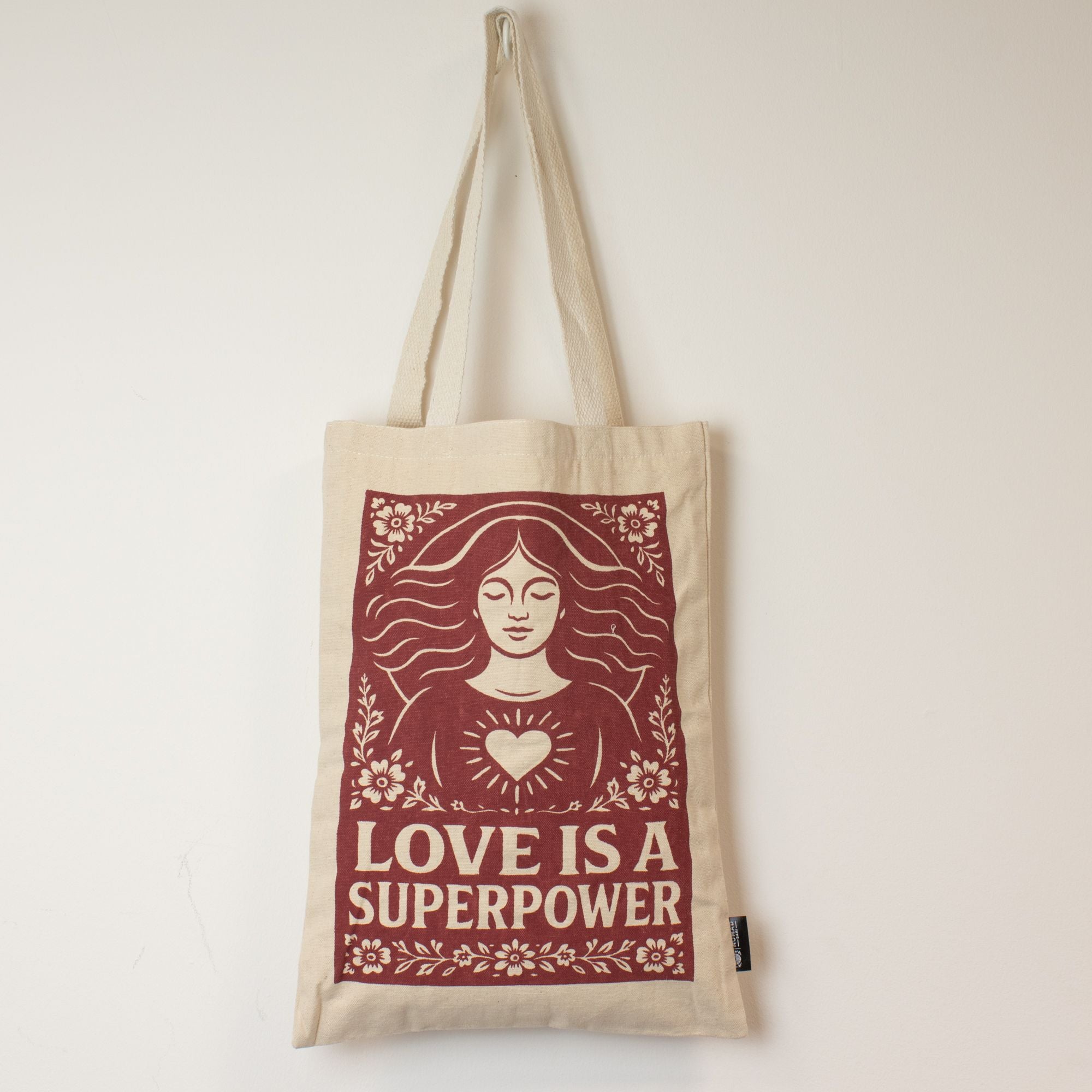 Tote bag with 'Love is a Superpower' design on a plain background