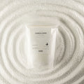 A white resealable pouch labeled 'CANDLE SAND' with 'ANCIENT MYSTERY' below, placed on a textured white surface with concentric circular ripples around it.