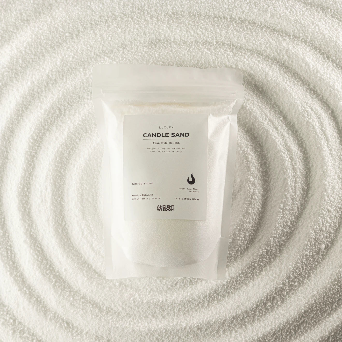A white resealable pouch labeled 'CANDLE SAND' with 'ANCIENT MYSTERY' below, placed on a textured white surface with concentric circular ripples around it.